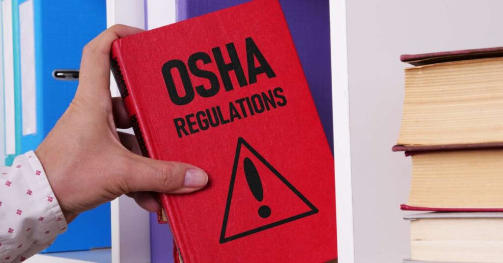 A man pulling a red book off a shelf. The title says "OSHA Regulations." The cover has a triangle with an exclamation point.